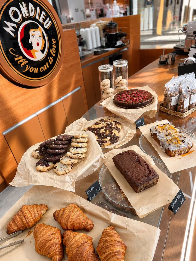 Káva s charakteristickým latte art Mondieu na dřevěném stole v Eurovei